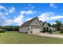 A well-maintained yard and a long driveway connect to an attached two-car garage at 71 Smithsanders Ct, Smithfield, NC 27577