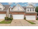 Inviting brick townhome featuring an attached garage, manicured lawn, and classic architectural details at 8004 Thrush Ridge Ln, Raleigh, NC 27615