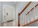 Welcoming foyer with tiled floors, staircase with wooden banister and light-filled glass accent front door at 8004 Thrush Ridge Ln, Raleigh, NC 27615