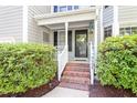 Inviting front porch with brick steps, complemented by manicured bushes and the house number at 9504 Anson Grove Lane Ln, Raleigh, NC 27615