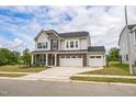 Two-story home with a three-car garage, stone accents, and a well-kept lawn at 1051 Jura Ridge Dr, Fuquay Varina, NC 27526