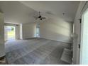 Spacious living room featuring vaulted ceilings, plush carpeting, a ceiling fan, and fireplace at 128 Oakfield Trace Dr, Four Oaks, NC 27524