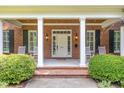 Inviting front porch with classic columns, rocking chairs, and neat landscaping at 1414 Park Dr, Raleigh, NC 27605