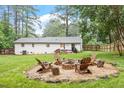 Spacious backyard with a fire pit, seating area, and a well-maintained lawn at 1523 Oak Forest Dr, Hillsborough, NC 27278