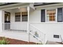 Inviting front porch with white railing, brick steps, and a charming front door at 1523 Oak Forest Dr, Hillsborough, NC 27278