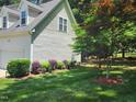 A lush side yard with manicured flowerbeds and a decorative tree at 18 Clover Hil Pl, Durham, NC 27712