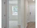 Bright entryway features luxury vinyl plank flooring, a white front door, and views of the living area at 185 Carriedelle Ln, Wilson's Mills, NC 27577