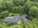 Stunning aerial view of a sprawling estate nestled amidst lush greenery, showcasing a private pool and meticulously landscaped grounds at 213 Chimeneas Pl, Chapel Hill, NC 27517