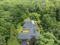 Breathtaking aerial view of a secluded home, featuring a long pool, surrounded by verdant forest for ultimate privacy at 213 Chimeneas Pl, Chapel Hill, NC 27517