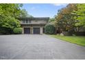 Two-story home with a wide driveway, two car garage, and mature landscaping; a welcoming entrance at 213 Chimeneas Pl, Chapel Hill, NC 27517
