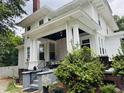 Inviting side porch features classic white columns and a charming porch swing at 275 Gholson Ave, Henderson, NC 27536