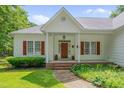 Close-up of the inviting front porch, red brick steps and wood-stained front door at 300 Williamston Ridge Dr, Youngsville, NC 27596