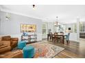 Open-concept living space with hardwood floors, a colorful rug, comfortable seating, and ample natural light from large windows at 304 Forbes Rd, Wake Forest, NC 27587