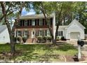 Two-story home with brick facade, green shutters, and detached two-car garage at 3045 Creek Moss Ave, Wake Forest, NC 27587