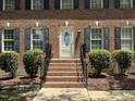 Close up of a traditional brick home with a white front door and brick steps leading to the entrance at 3045 Creek Moss Ave, Wake Forest, NC 27587