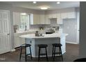 Bright kitchen with white cabinets, stainless steel appliances, a peninsula island and a view into the living room at 3045 Creek Moss Ave, Wake Forest, NC 27587