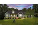 Inviting exterior featuring dormers, a bay window, and a covered porch, all surrounded by lush greenery at 3113 Golden Nugget Dr, Clayton, NC 27520