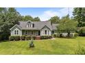 Inviting exterior featuring dormers, a bay window, and a covered porch, all surrounded by lush greenery at 3113 Golden Nugget Dr, Clayton, NC 27520