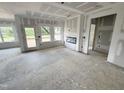 Unfinished living room with three windows, a door to backyard and a modern fireplace awaiting your personal touch at 360 Ambassador Dr, Clayton, NC 27520