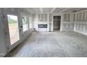 Large living room featuring a fireplace, a door to the backyard, and plenty of natural light at 360 Ambassador Dr, Clayton, NC 27520