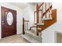 Inviting entryway featuring a wood-trimmed staircase and a stylish front door with decorative glass at 3605 Iron Sight Ct, Raleigh, NC 27616