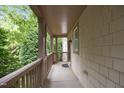 Inviting covered porch featuring wood columns, railings and views of mature trees at 4511 Crab Creek Dr # 101, Raleigh, NC 27612