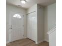 Inviting entryway with a white door, wood-look flooring, and ample closet space at 5225 Big Bass Dr, Raleigh, NC 27610