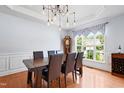 Spacious dining room with a modern chandelier, wooden table and large windows at 534 Siltstone Pl, Cary, NC 27519