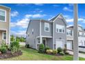 Stylish two-story home with a one car garage, green lawn, and attractive stone accents at 6549 Tremolo Trl, Raleigh, NC 27616