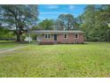 Charming brick home featuring a spacious front yard, complemented by mature trees and a welcoming facade at 658 Love Grove Church Rd, Sanford, NC 27332