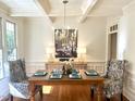 Elegant dining room featuring a coffered ceiling, chandelier, and stylish decor for sophisticated gatherings at 709 Skymont Dr, Holly Springs, NC 27540