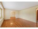 Open living space featuring hardwood floors, neutral walls, and view of dining area at 7620 Harps Mill Rd, Raleigh, NC 27615