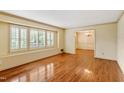 Spacious living room featuring hardwood floors and ample natural light from shuttered windows at 7620 Harps Mill Rd, Raleigh, NC 27615