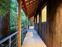 Inviting deck with wood railing offers a serene outdoor space surrounded by trees at 820 Runnymede Rd Rd, Raleigh, NC 27607