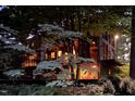 Unique home exterior nestled among trees, featuring balcony and warm interior lighting at 820 Runnymede Rd Rd, Raleigh, NC 27607