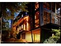Close-up of wood-clad exterior with unique architectural details and warm lighting at night at 820 Runnymede Rd Rd, Raleigh, NC 27607