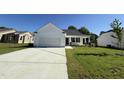 Charming single-story home with a two-car garage, inviting front porch, and well-maintained lawn at 91 Oakfield Trace Dr, Four Oaks, NC 27524