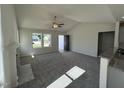 Bright living room featuring neutral carpet, a ceiling fan, a fireplace, and plenty of natural light at 91 Oakfield Trace Dr, Four Oaks, NC 27524