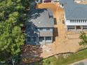 New construction exterior elevation of a blue home with a gray roof surrounded by mature trees and a partially landscaped yard at 1221 Dixie Trl, Raleigh, NC 27607