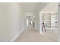 Spacious hallway with white walls and light hardwood floors leading to a built-in bookcase room and staircase at 1221 Dixie Trl, Raleigh, NC 27607