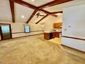 Spacious living room with vaulted ceilings, wooden beams, carpeted floors, and an adjacent kitchen area at 1306 Oakridge Ave, Henderson, NC 27536