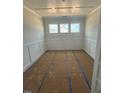 Bright living room with three windows, white walls, wainscotting, and coffered ceilings at 140 Sawtooth Oak Ln, Youngsville, NC 27596