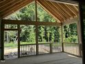 Spacious screened porch with wood flooring and exposed beams, overlooking a lush, wooded backyard at 152 Big Bradley Dr, Wendell, NC 27591