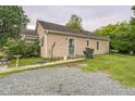 Home exterior featuring a gravel driveway, well-kept lawn, and convenient side entry at 1726 Morgantown Rd, Burlington, NC 27217