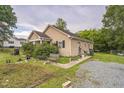 Inviting home exterior with lush landscaping, gravel driveway, and charming details at 1726 Morgantown Rd, Burlington, NC 27217