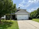 Gray two-story home with landscaping, a two-car garage, and a concrete driveway at 219 Trimble Dr, Elon, NC 27244