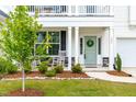 Inviting front porch with rocking chairs and a beautifully landscaped garden area at 222 Oak Branch - Lot 72 Trl, Garner, NC 27529