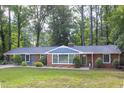Attractive single-story brick home featuring lush landscaping and a well-manicured front lawn at 2801 E Shoreham St, Durham, NC 27707