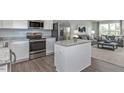 Modern kitchen with stainless steel appliances, gray countertops, and an island open to a living space at 290 Grand Silo Rd, Raleigh, NC 27603