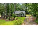 Well-maintained single-story home surrounded by lush greenery and mature trees, offering privacy and tranquility at 296 Gordon Farm Dr, Benson, NC 27504